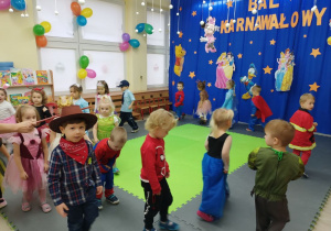Dzieci przechodzą pod laską gimnastyczną w rytm muzyki